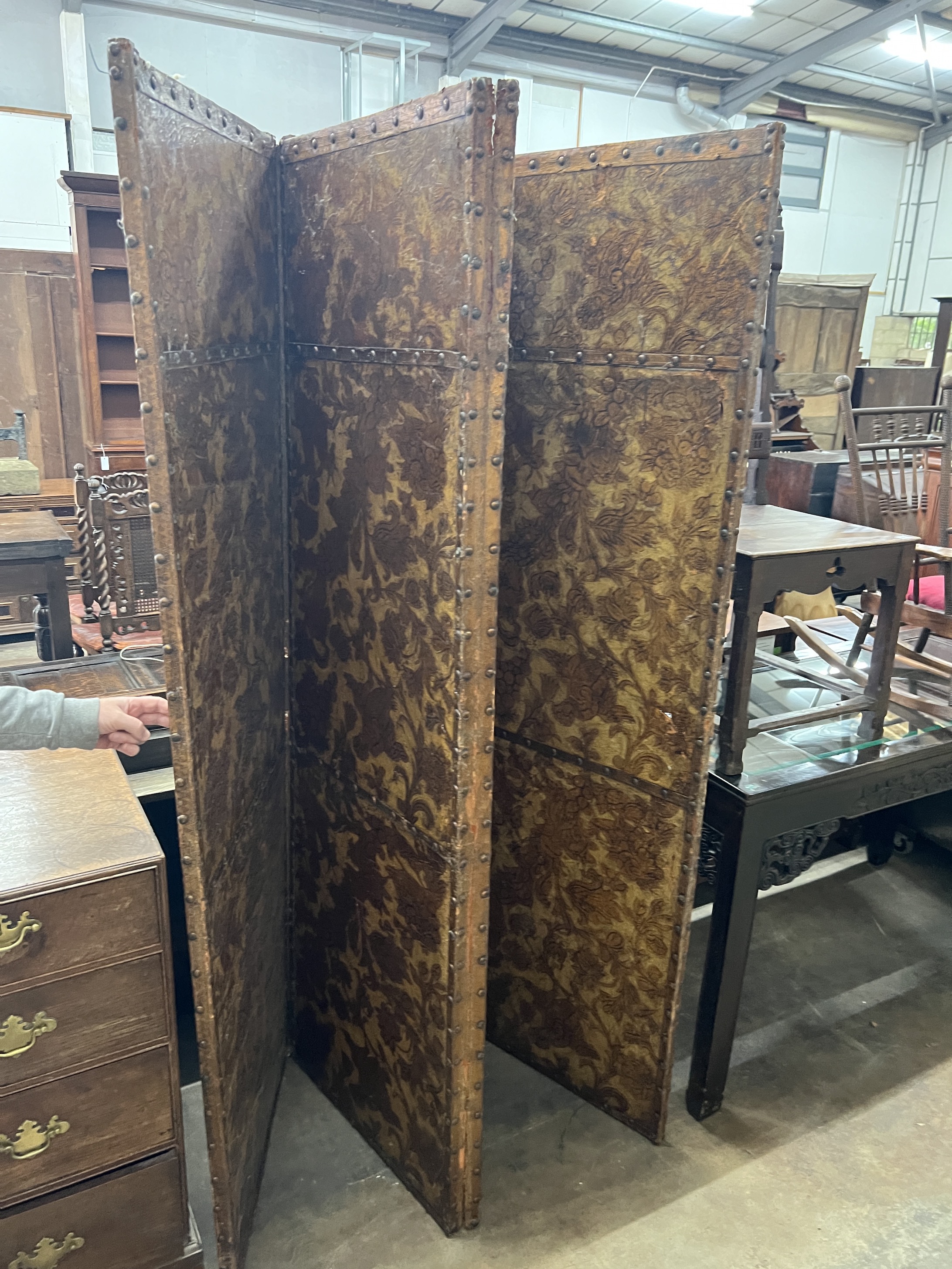 An 18th century Dutch leather four fold painted dressing screen, each panel width 61cm, height 198cm